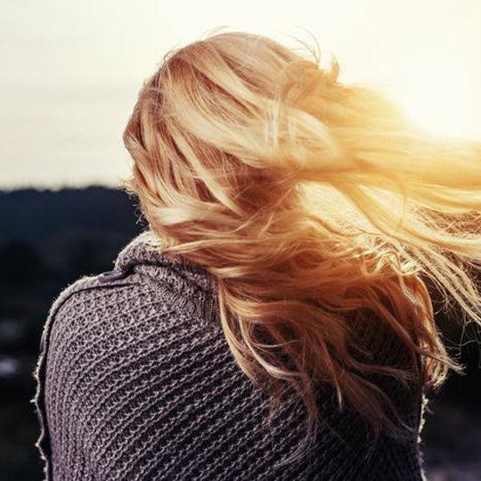 Les cheveux d'une femme sans poux soufflent au vent