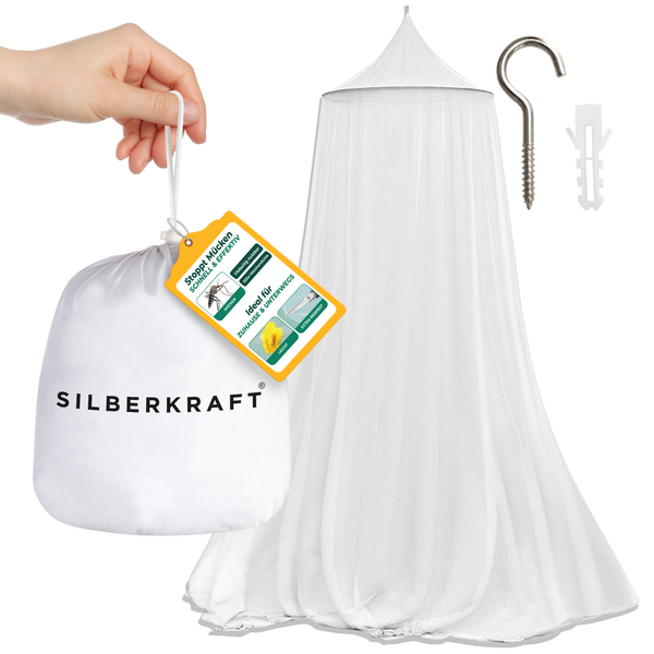 Une main tient le sac d'emballage de la moustiquaire Silberkraft. En arrière-plan, vous pouvez voir le filet tendu, une cheville et un crochet mural.